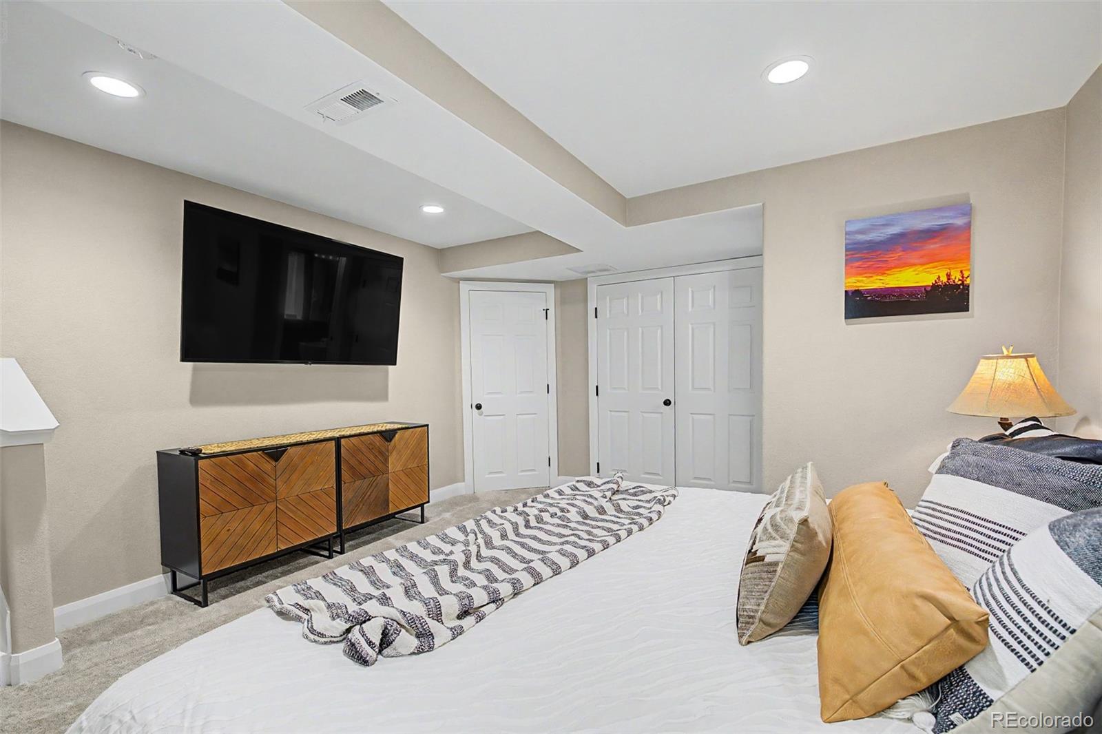 10246 South Spotted Owl Avenue Highlands Ranch, CO 80129 - Photo 24 of 49 a bedroom with a bed and a flat screen tv