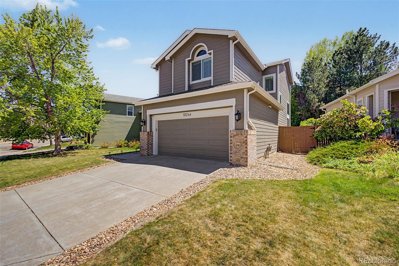 10246 South Spotted Owl Avenue Highlands Ranch, CO 80129 - Photo 3 of 49 a front view of a house with a yard and garage