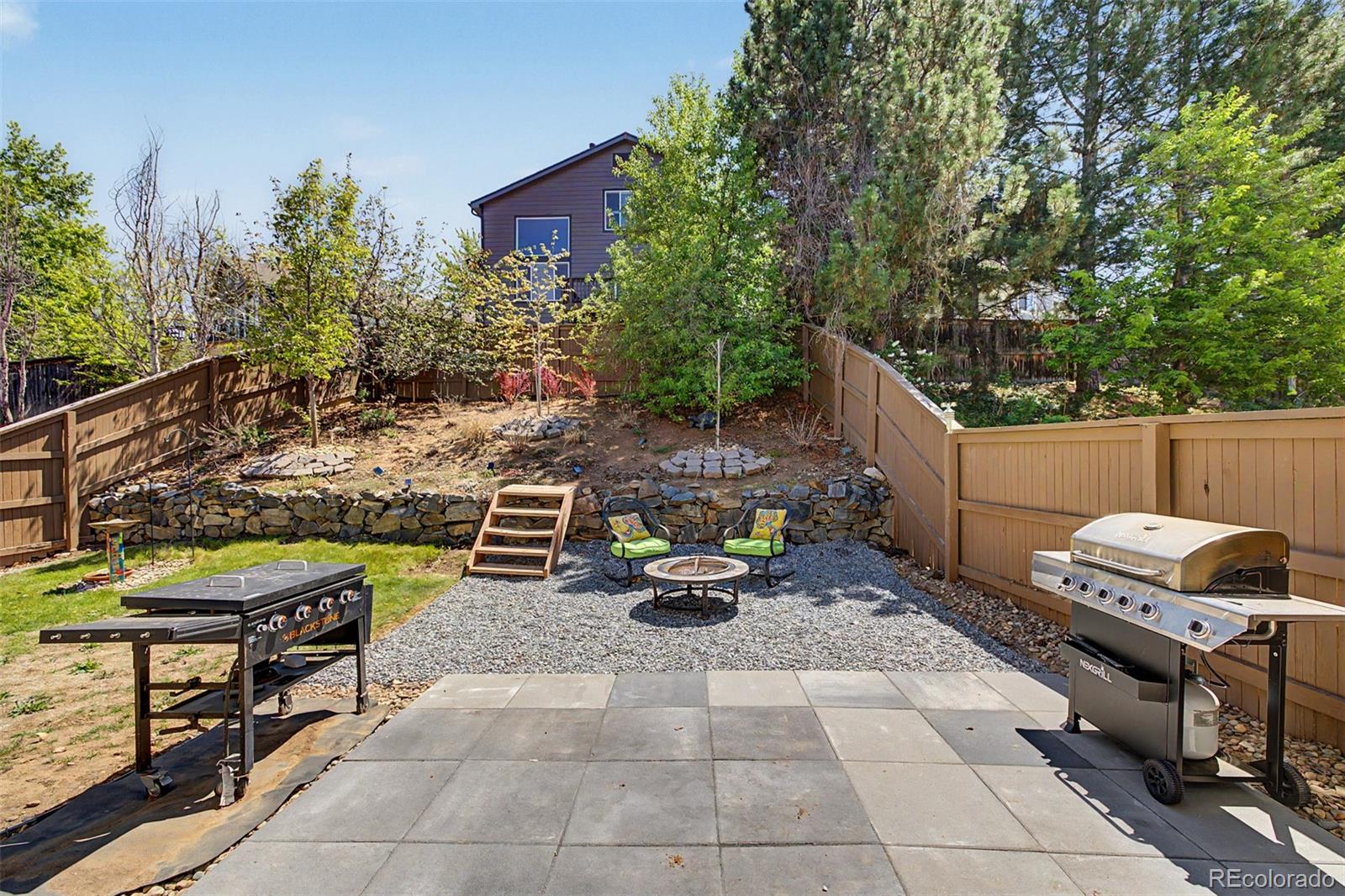 10246 South Spotted Owl Avenue Highlands Ranch, CO 80129 - Photo 40 of 49 a view of a backyard with chairs and iron fence