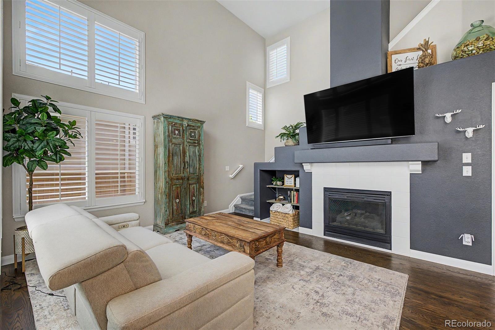10246 South Spotted Owl Avenue Highlands Ranch, CO 80129 - Photo 4 of 49 a living room with furniture a flat screen tv and a fireplace
