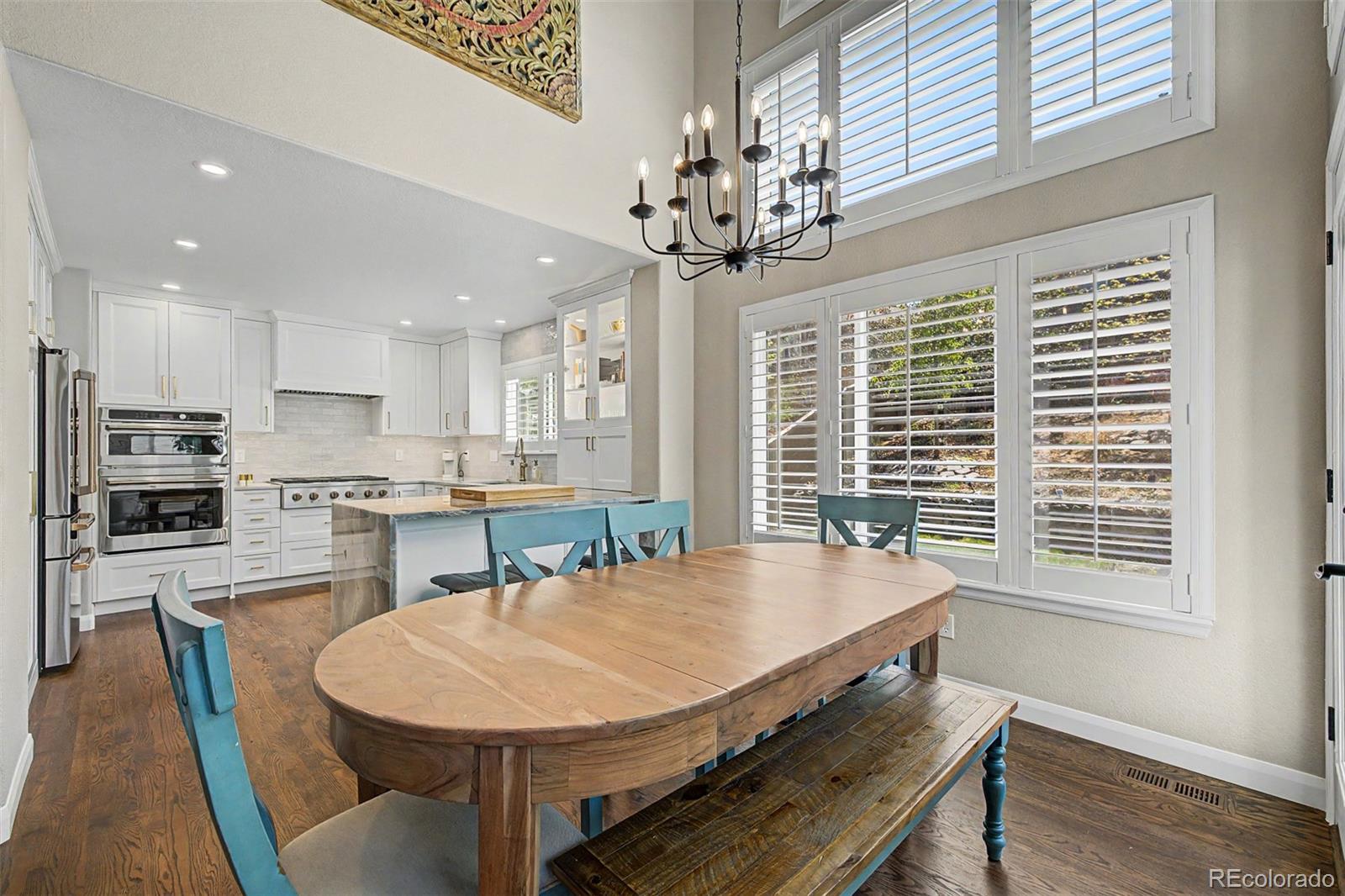 10246 South Spotted Owl Avenue Highlands Ranch, CO 80129 - Photo 9 of 49 a dining room with wooden floor and chandelier