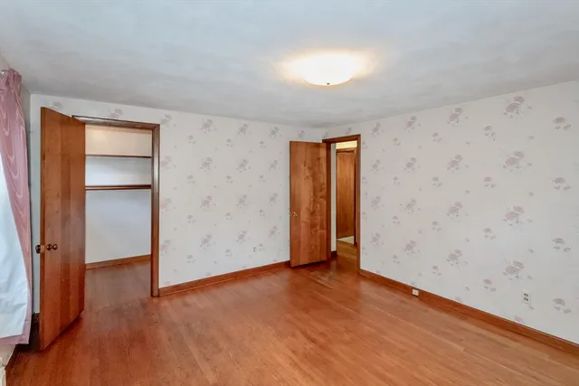 an empty room with wooden floor and closet