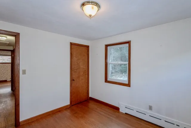 an empty room with window and wooden floor