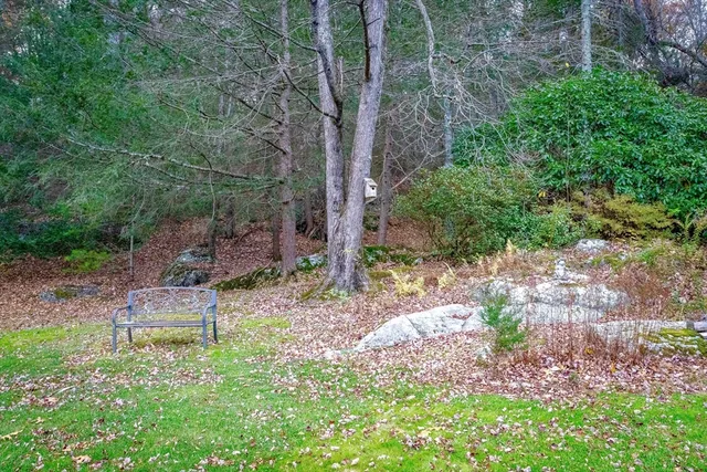 a front view of a house with a garden and trees