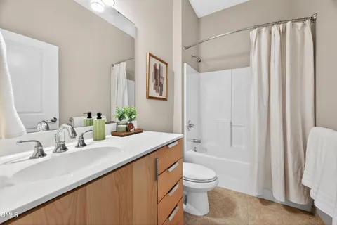 a bathroom with a granite countertop sink a toilet and shower