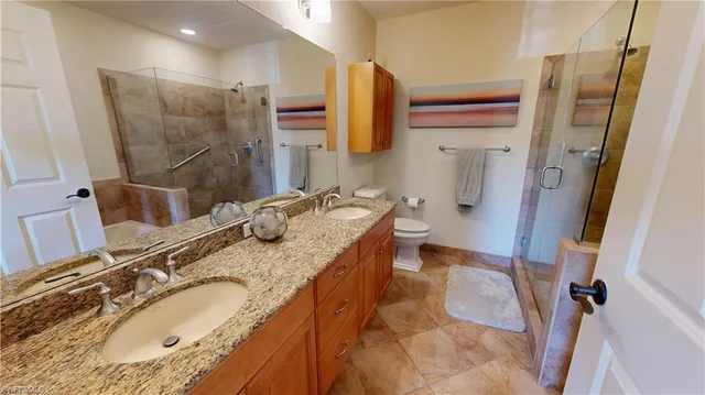 a bathroom with a granite countertop double vanity sink and mirror