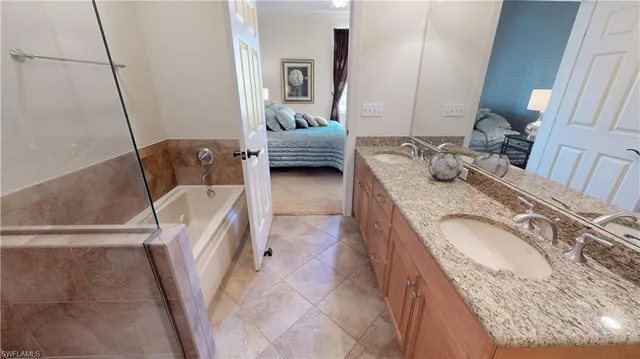 a en suite bathroom with a granite countertop sink and a mirror