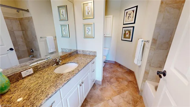 a bathroom with a granite countertop tub sink and mirror