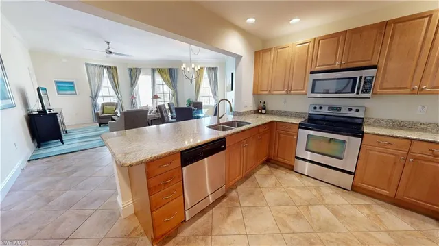 a large kitchen with stainless steel appliances granite countertop a stove a sink and a microwave