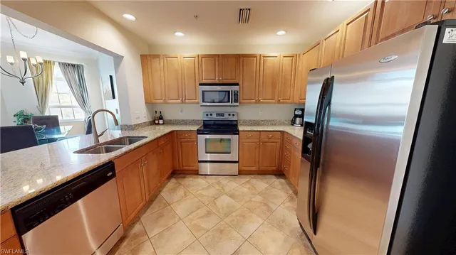 a kitchen with stainless steel appliances a refrigerator sink and microwave