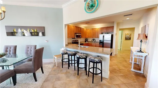 a dining area with stainless steel appliances a dining table chairs and stove