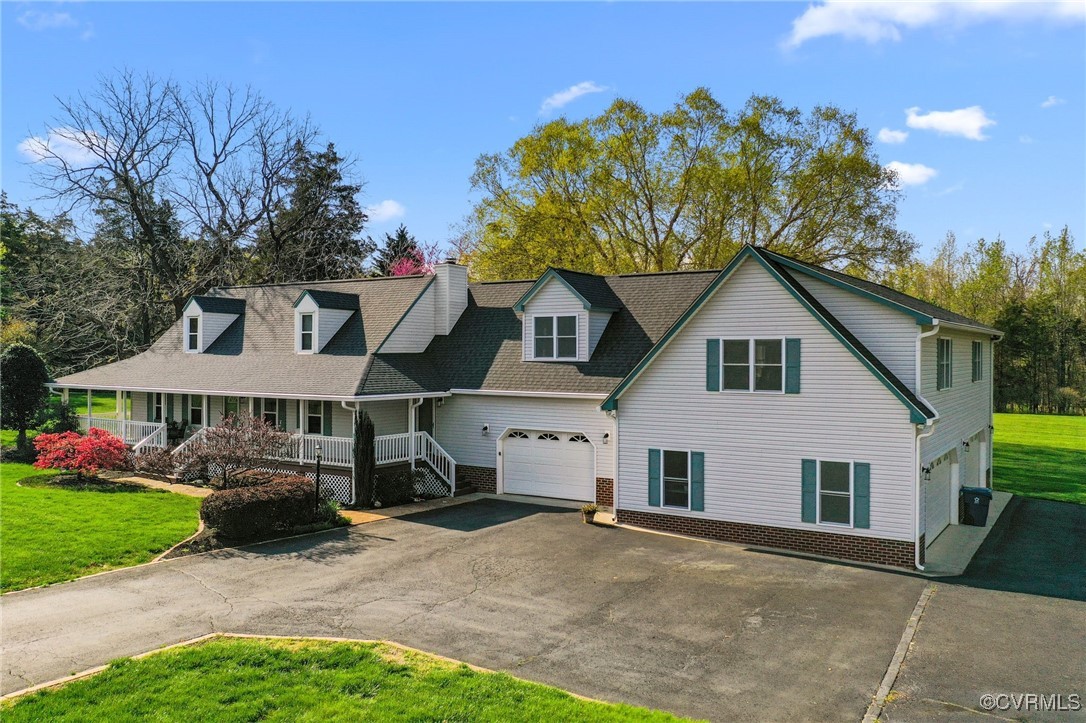 Cape cod-style house with brick siding, driveway,