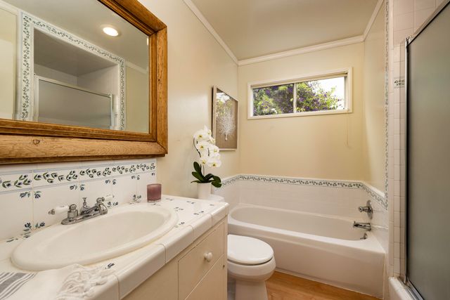 a bathroom with a bathtub sink mirror and toilet