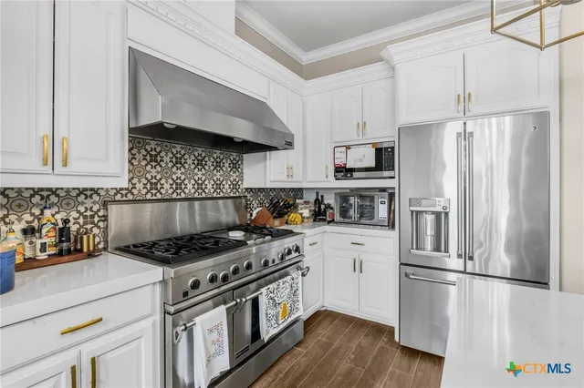 a kitchen with kitchen island a counter top space stainless steel appliances and wooden floor