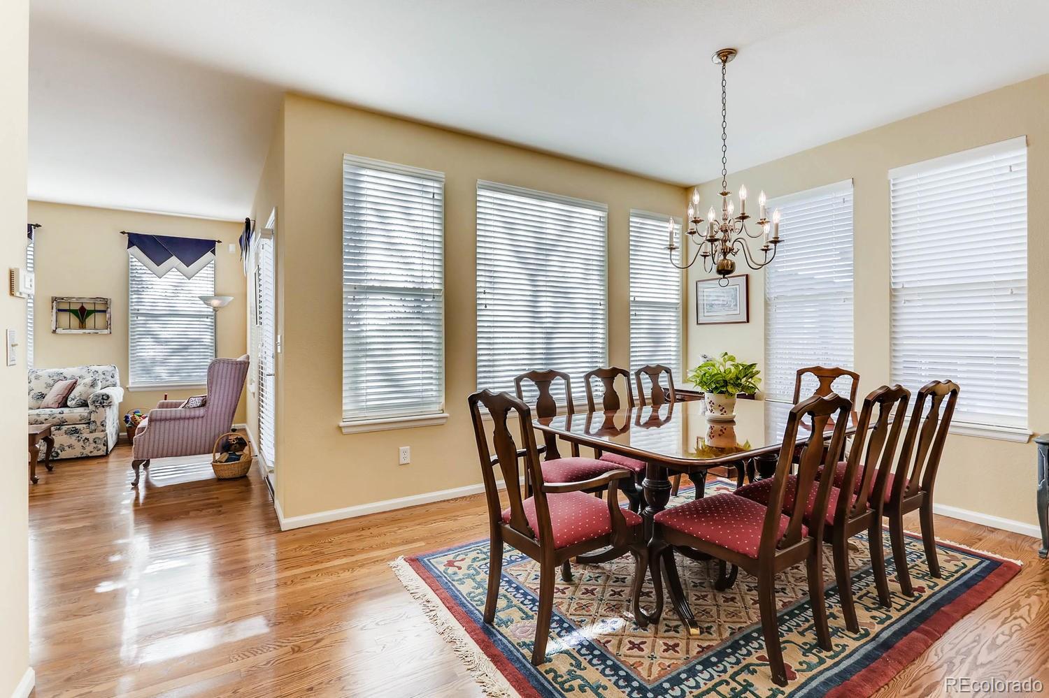 10825 Towerbridge Road Highlands Ranch, CO 80130 - Photo 12 of 24 a view of a dining room with furniture wooden floor and chandelier