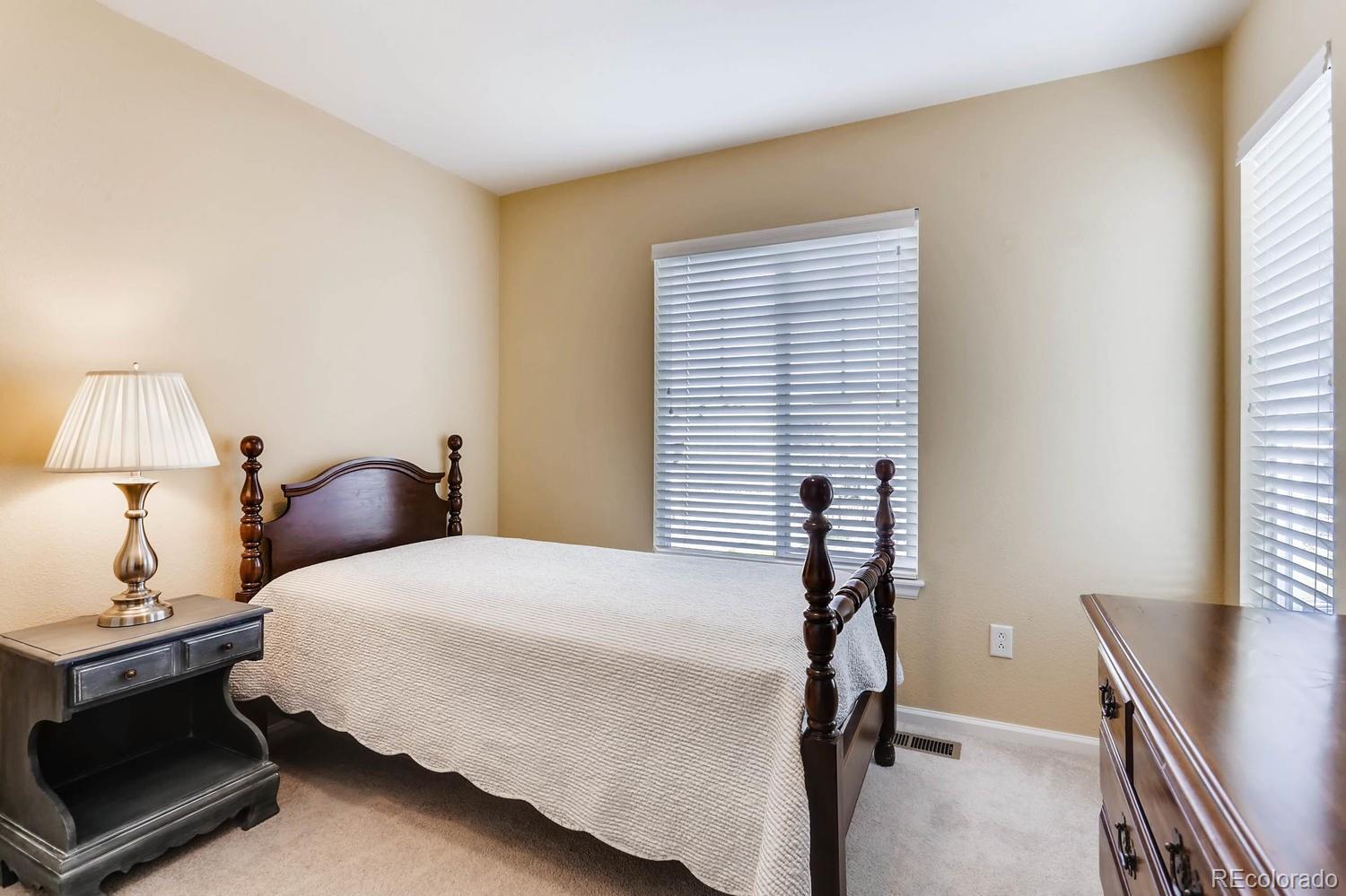 10825 Towerbridge Road Highlands Ranch, CO 80130 - Photo 17 of 24 a bedroom with a bed and a window
