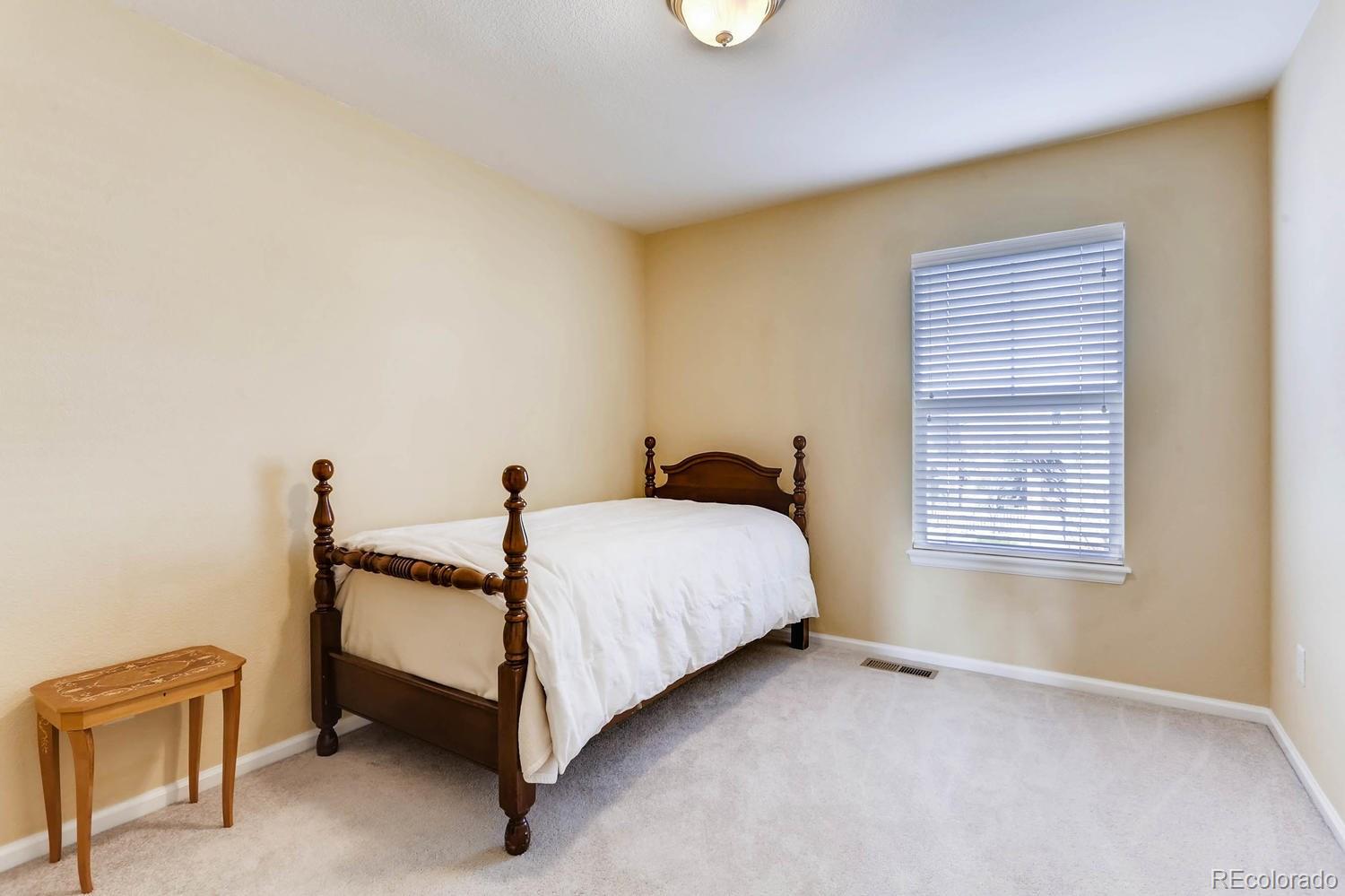 10825 Towerbridge Road Highlands Ranch, CO 80130 - Photo 18 of 24 a bed room with a bed and a chair