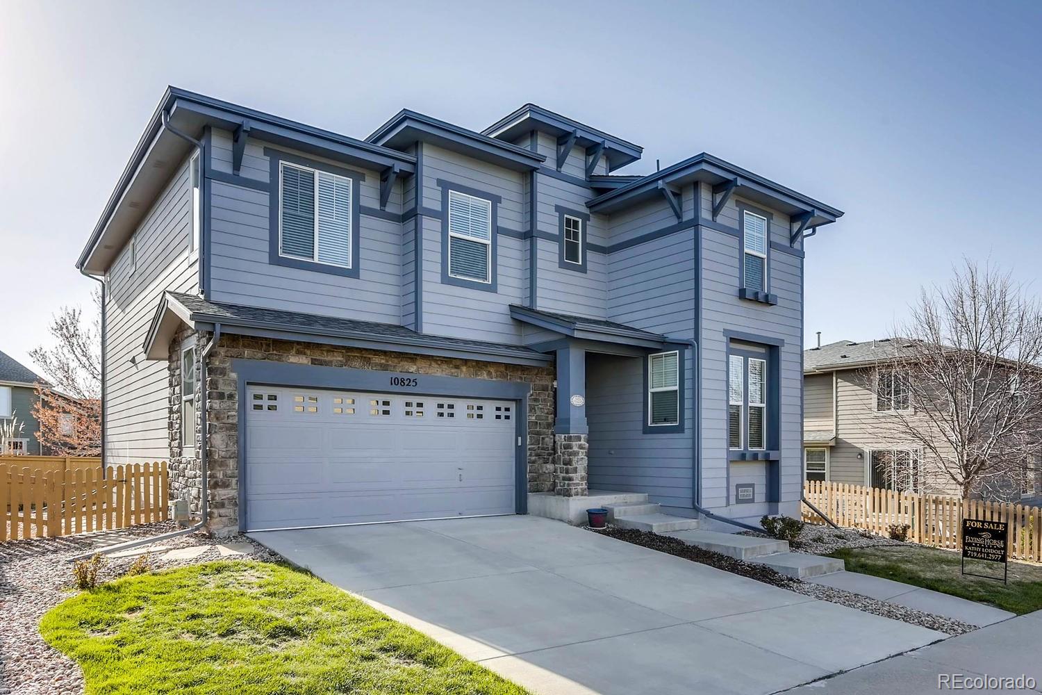10825 Towerbridge Road Highlands Ranch, CO 80130 - Photo 3 of 24 a front view of a house with a garden