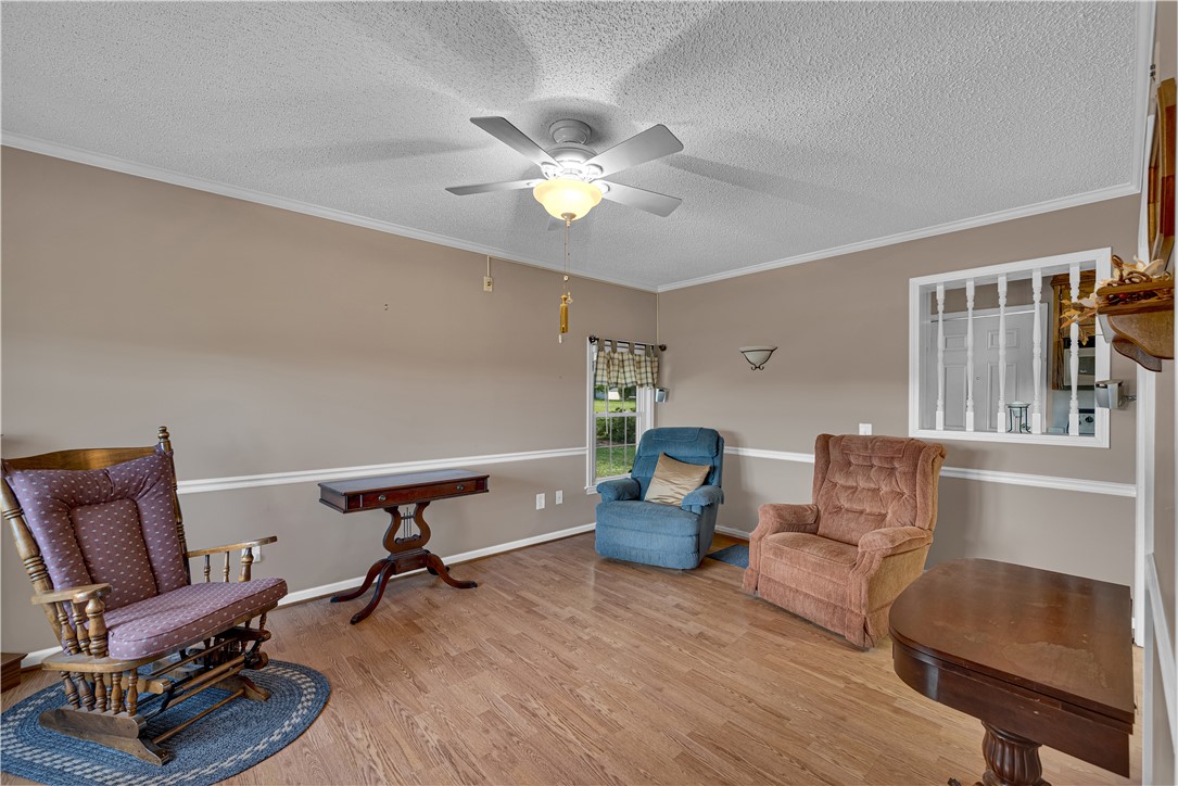 307 Calhoun Road Belton, SC 29627 - Photo 14 of 30 Warm wood flooring extends throughout this versatile living area, complemented by a ceiling fan for comfort.