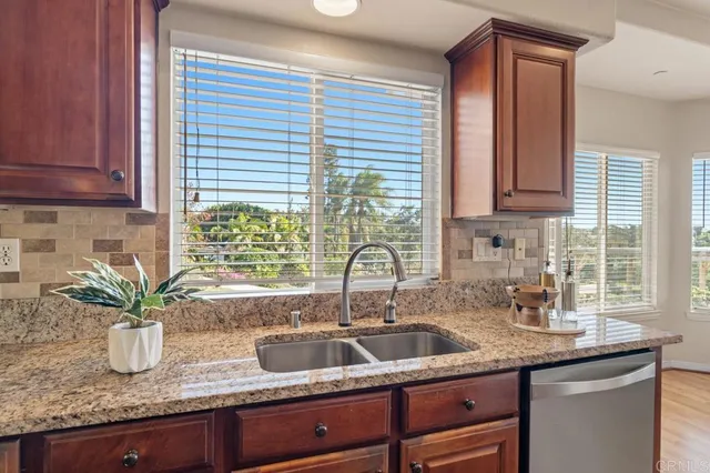 a bed sitting in a bedroom next to a window and a potted plant