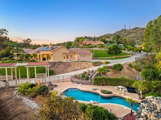 a view of a big house with a big yard and large trees