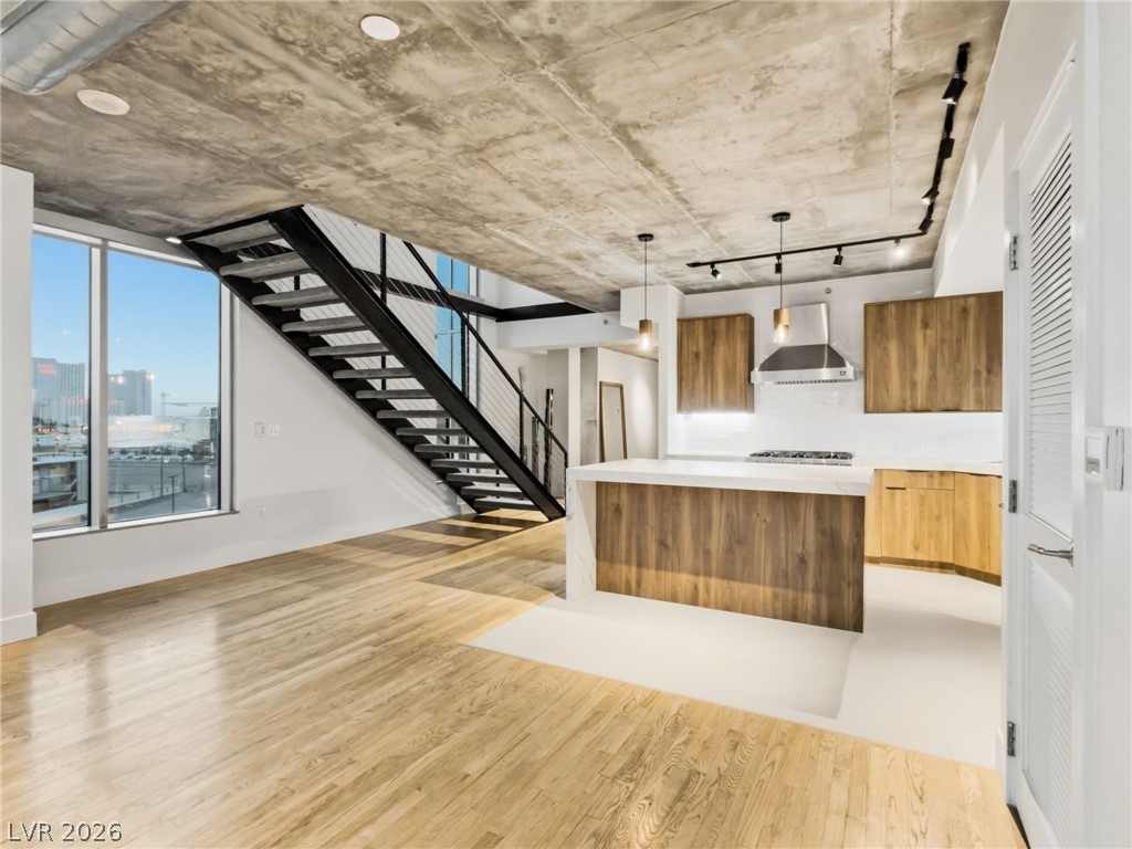 360 East Desert Inn Road, Unit 607 Las Vegas, NV 89109 - Photo 11 of 55 A vibrant living space featuring an industrial-style staircase and a modern kitchen with a view.