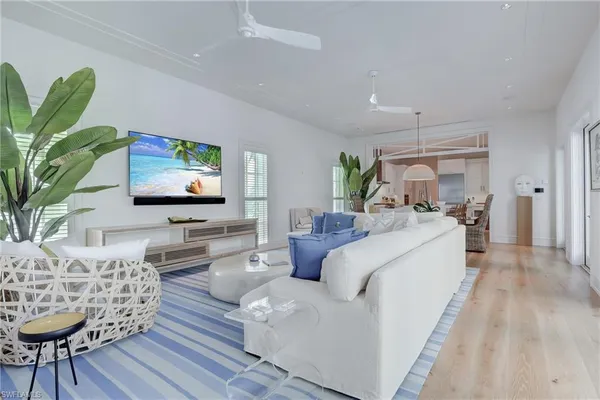 a living room with furniture a flat screen tv and a potted plant
