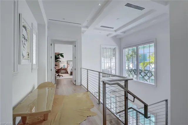 a view of a hallway with furniture and a window