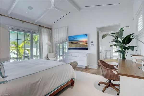 a bedroom with a bed a large window and furniture