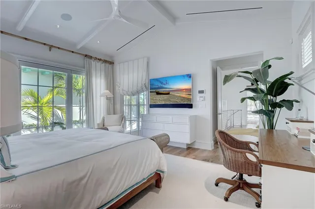 a bedroom with a bed a large window and furniture