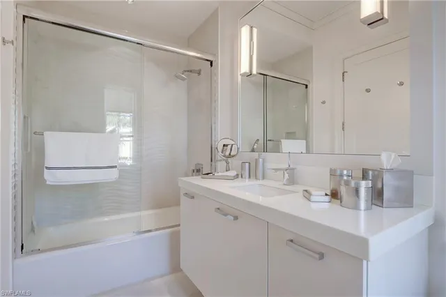 a bathroom with a shower sink vanity and mirror