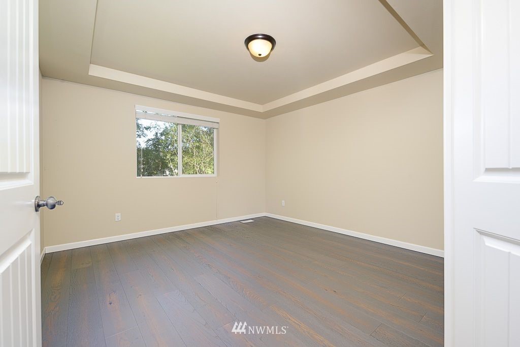 357 Field Place Northeast Renton, WA 98059 - Photo 12 of 26 an empty room with wooden floor and windows