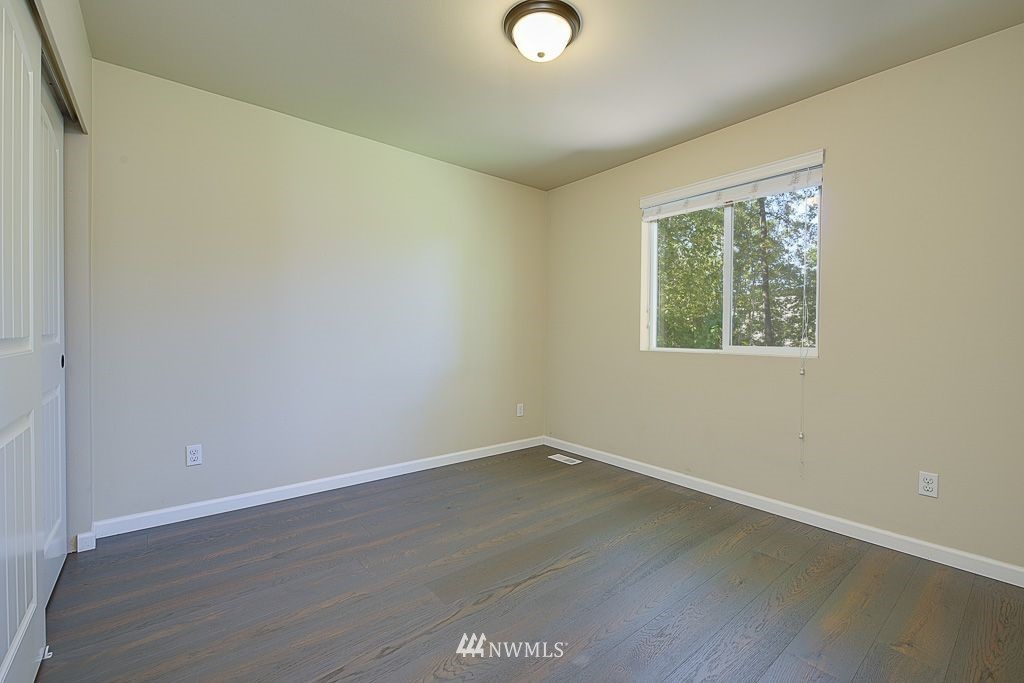 357 Field Place Northeast Renton, WA 98059 - Photo 17 of 26 an empty room with wooden floor and windows