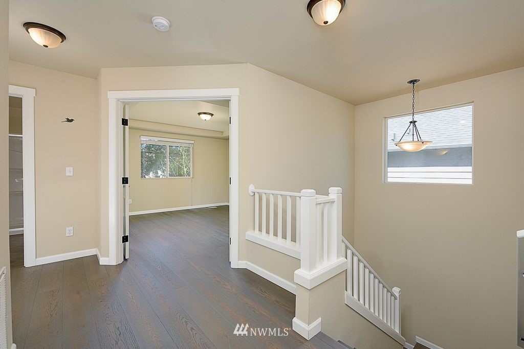 357 Field Place Northeast Renton, WA 98059 - Photo 20 of 26 an empty room with wooden floor cabinet and windows