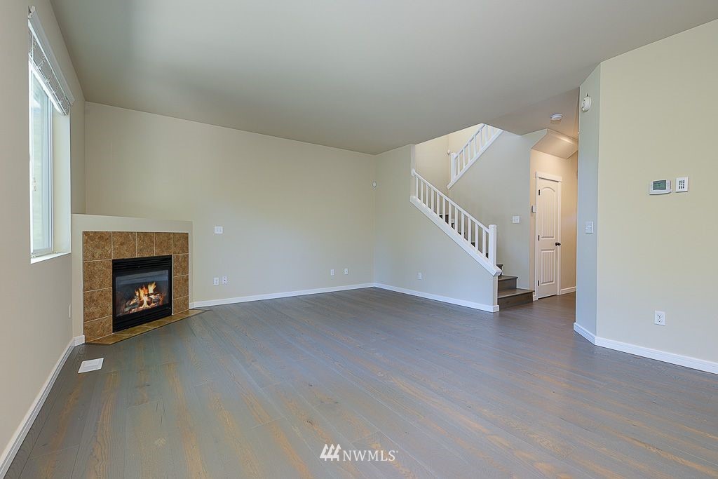357 Field Place Northeast Renton, WA 98059 - Photo 6 of 26 a view of an empty room with wooden floor and a fireplace