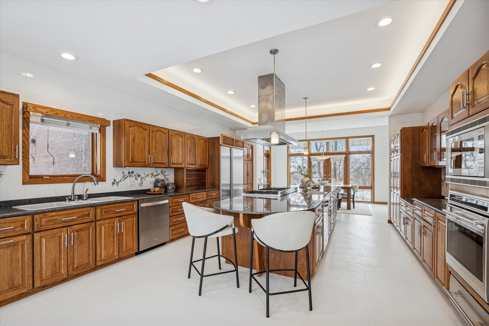 8425 Hickory Court Burr Ridge, IL 60527 - Photo 12 of 53 a kitchen with stainless steel appliances granite countertop a stove a sink dishwasher a dining table and chairs with wooden floor