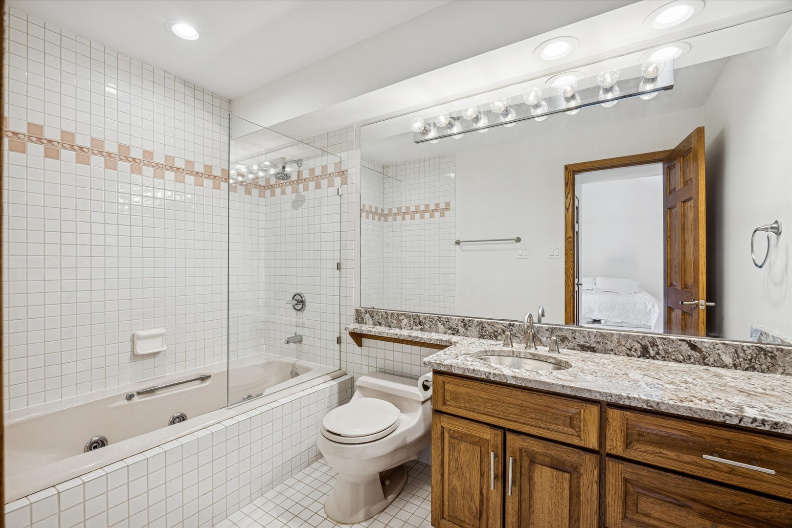 8425 Hickory Court Burr Ridge, IL 60527 - Photo 22 of 53 a bathroom with a granite countertop sink a toilet a mirror a bathtub and shower