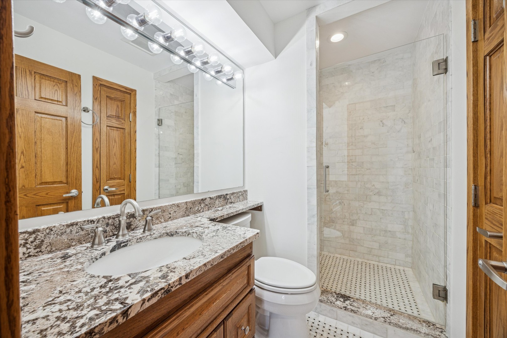 8425 Hickory Court Burr Ridge, IL 60527 - Photo 24 of 53 a bathroom with a granite countertop sink a toilet a mirror and shower