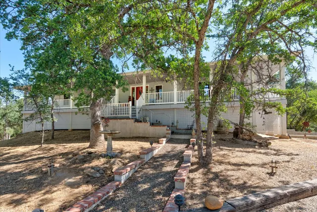 a backyard of a house with barbeque oven and trees