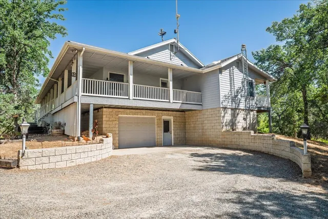 a view of a white house with large windows and a tree