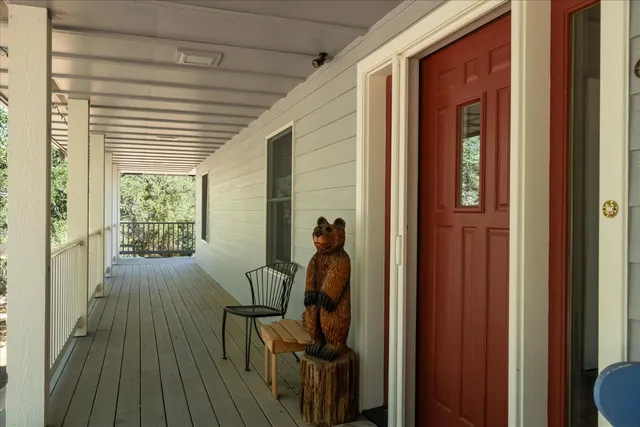 a living room with furniture large windows and wooden floor