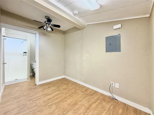 a view of a room with wooden floor and a ceiling fan