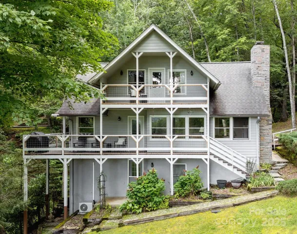 a front view of a house with a yard and potted plants