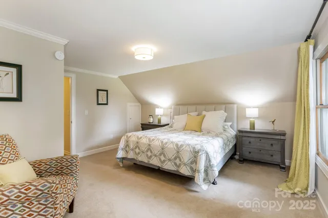 a bedroom with a bed and a lamp on dresser