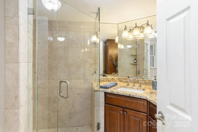 a bathroom with a double vanity sink a mirror and shower