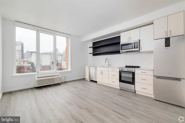a kitchen with stainless steel appliances a refrigerator and a stove top oven