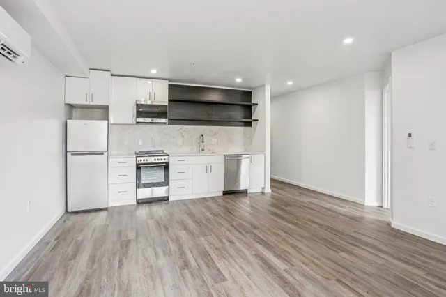 a view of kitchen with stainless steel appliances refrigerator stove microwave and cabinets
