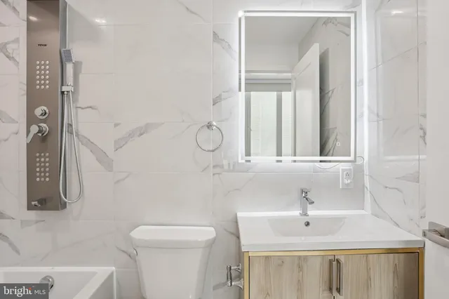 a bathroom with a sink a toilet and a mirror