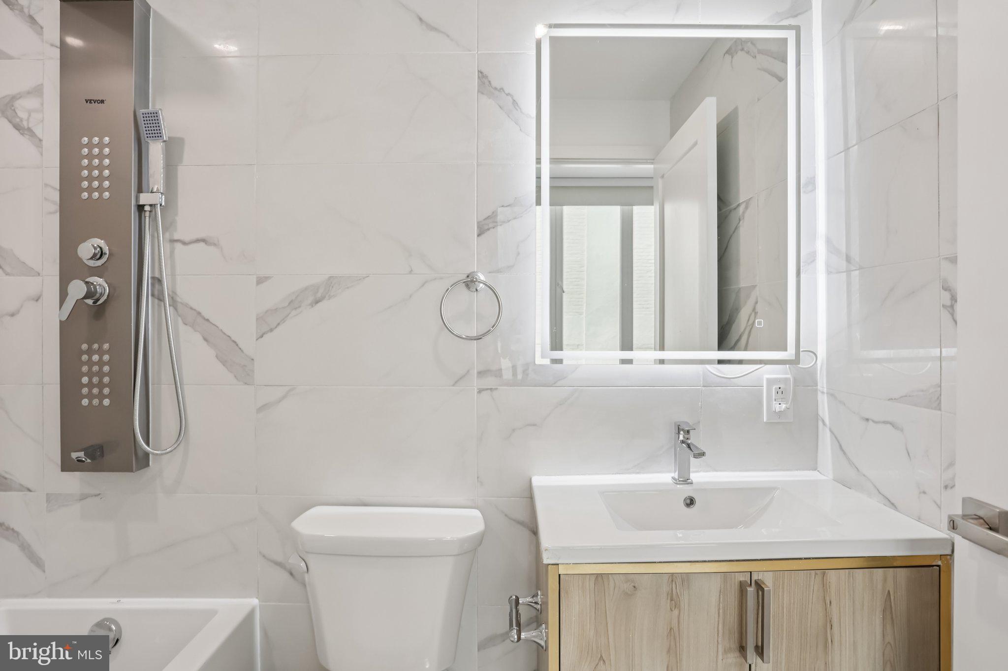 1201 Vine Street, Unit 1 Philadelphia, PA 19107 - Photo 6 of 32 a bathroom with a sink a toilet and a mirror