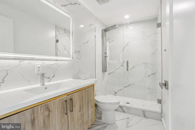 a bathroom with a sink a toilet and shower